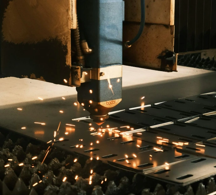 A machine cutting a piece of metal with sparks